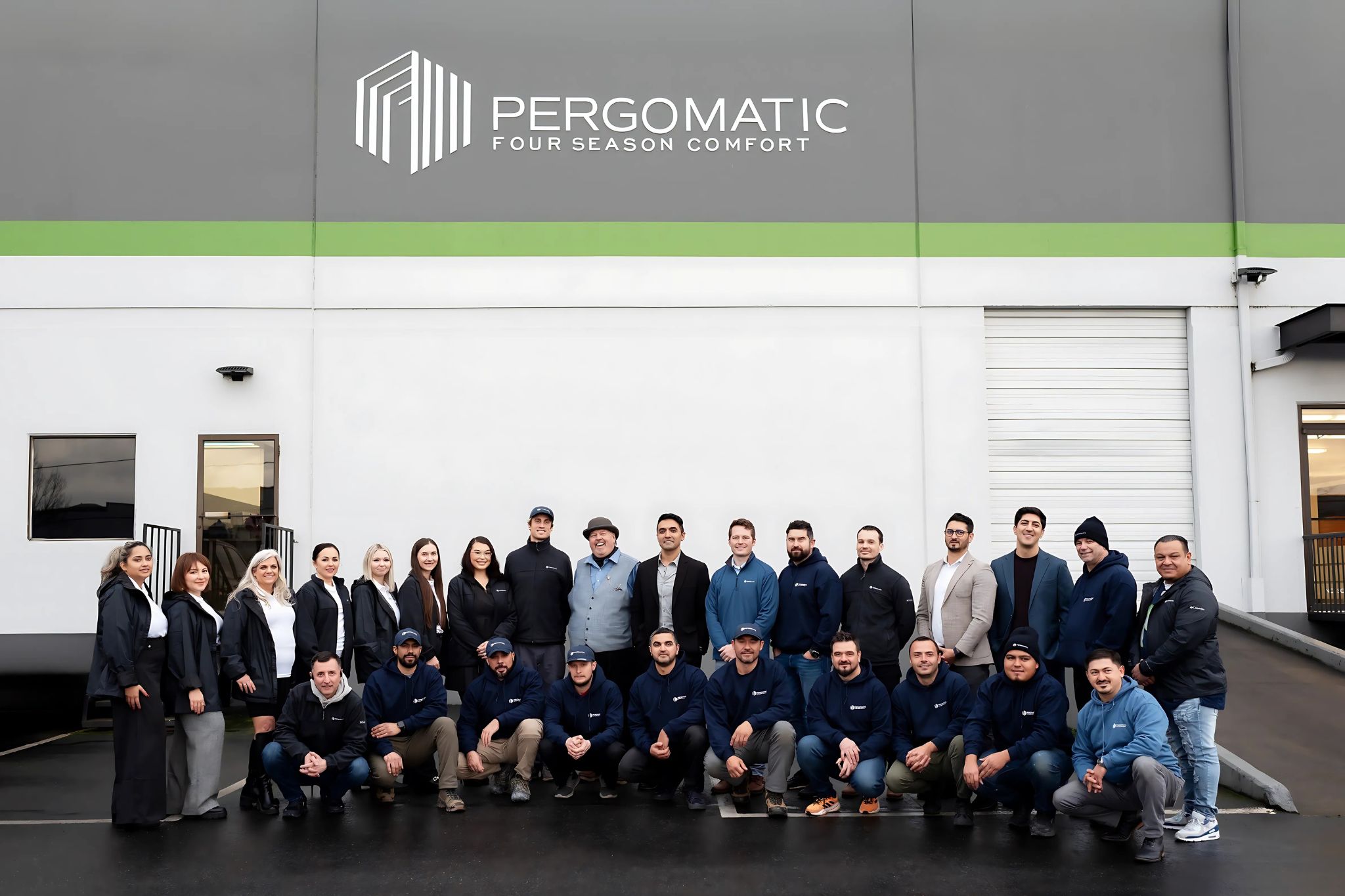Pergomatic team of designers, fabricators and installers poses outside HQ under large Pergomatic Four Season Comfort logo.